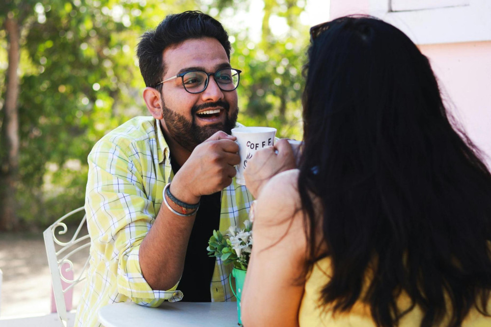 Man and woman laughing on a first date at a cute outdoor cafe