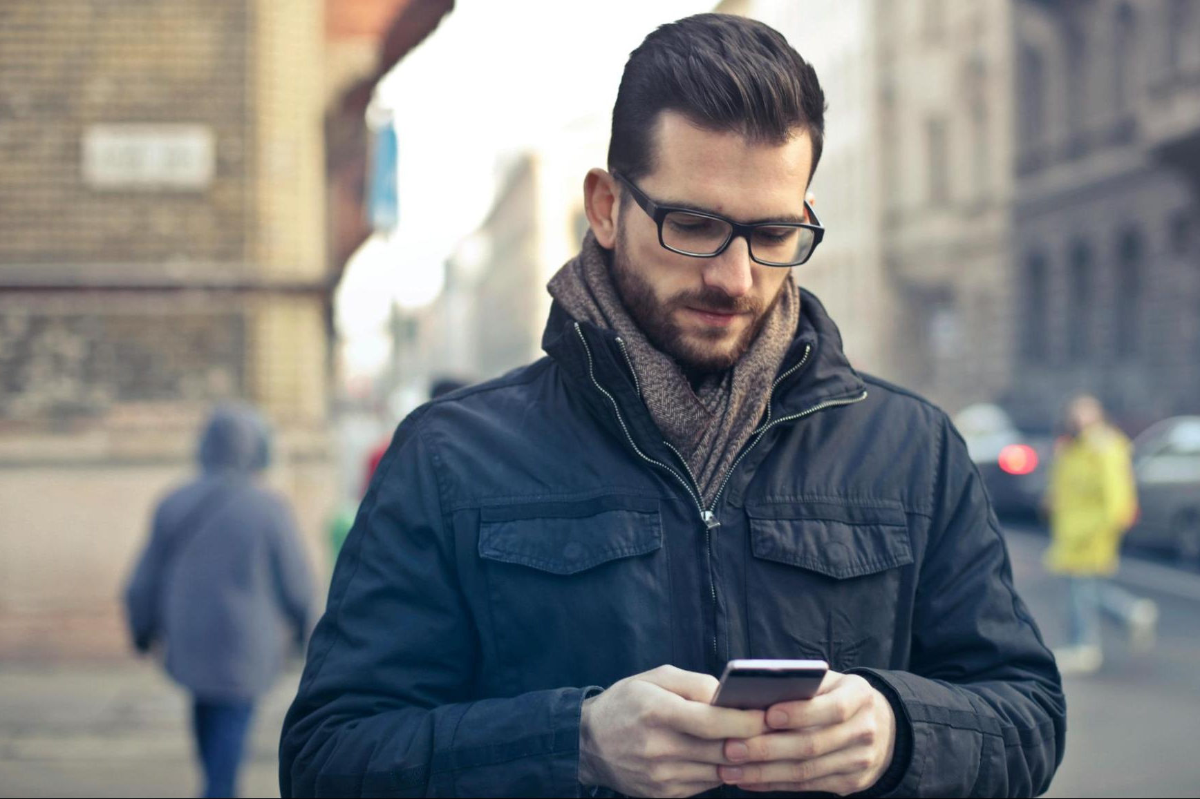 Man on the street reading women's Tinder dating app bios