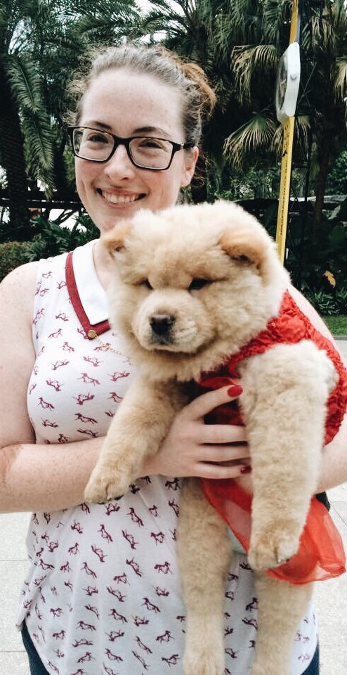 Woman in a tanktop, glasses, smiling with her puppy dog