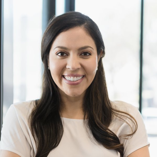 Woman in business casual attire smiling into the camera