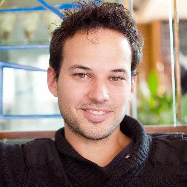 Man in his 30s, portrait shot, with a black sweater, smiling into the camera