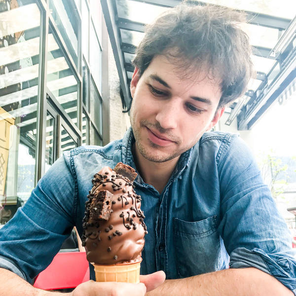 Man looking casual, brown hair, staring at his chocolate ice cream cone